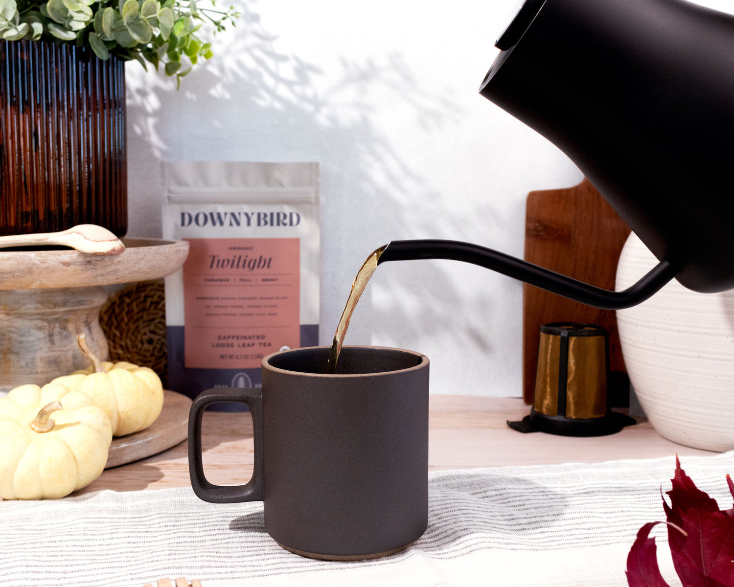 Kettle Pouring Downybird Organic Loose Leaf Tea into Mug with Dowybird Twilight Chai Tea Pouch in Background